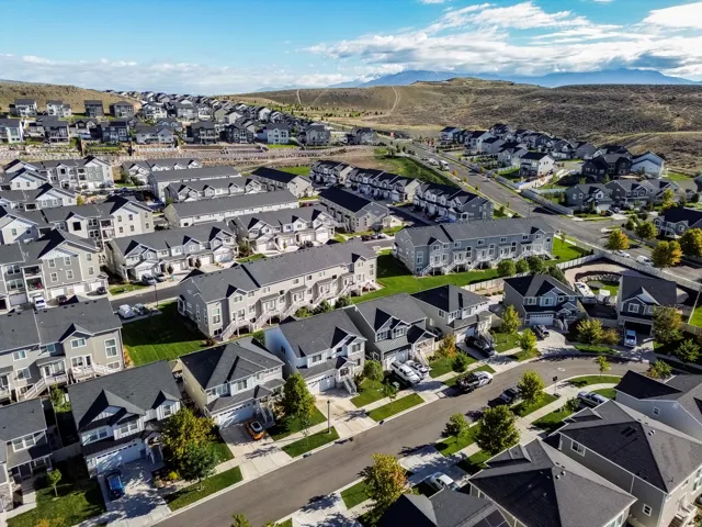 Established neighborhood with varied housing styles, paved streets, and mountain backdrop