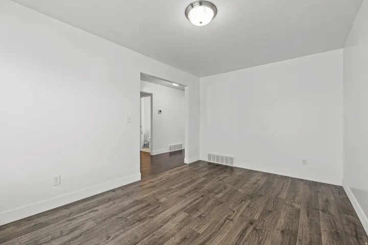 Wood-finish flooring, white wall finishes, and a flush mount ceiling light fixture