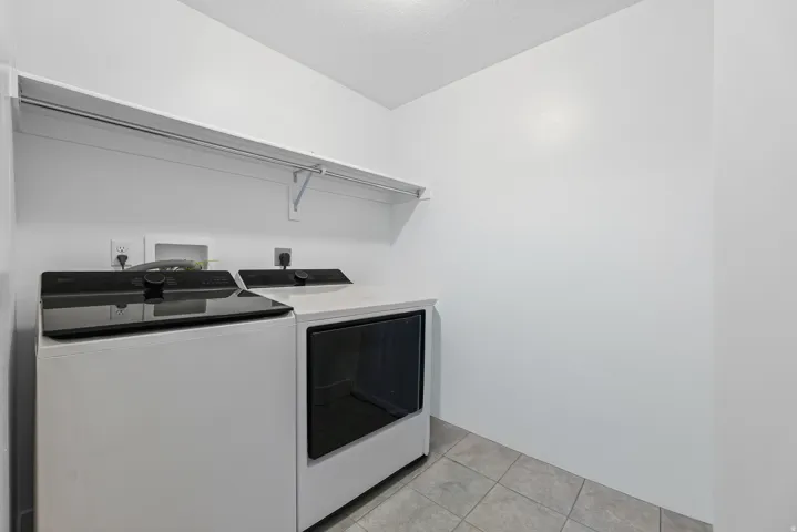 Built-in shelving unit, integrated clothes hanging rod, tile flooring, and light-toned wall finishes