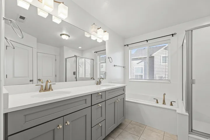 Master bathroom - Dual vanity with stone countertop, undermount sinks, and brushed gold fixtures