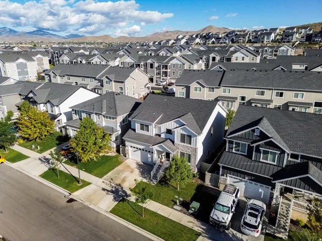 Contemporary residences with pitched roofs, individual garages, and front landscaping
