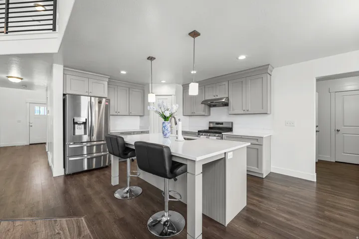 Kitchen featuring gray shaker cabinetry, white countertops, stainless steel appliances, and wood-finish flooring