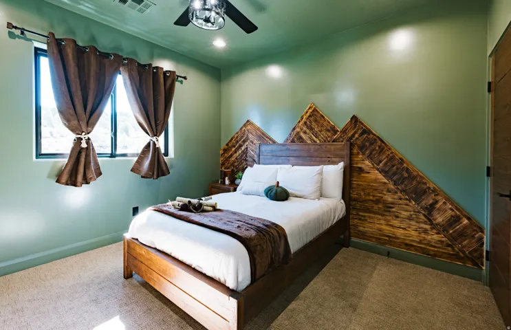 Built-in wood-finish accent wall, window with natural light, recessed lighting, ceiling fan, and wood-finish door