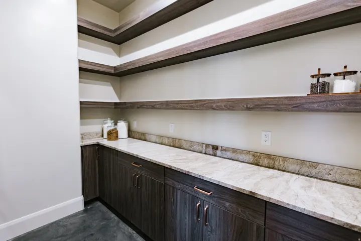 Built-in shelving and cabinetry with wood-finish doors and copper-tone hardware