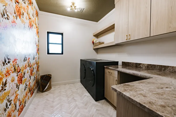 Herringbone tile flooring, wood-finish cabinetry, floating shelving, and a dark-framed window