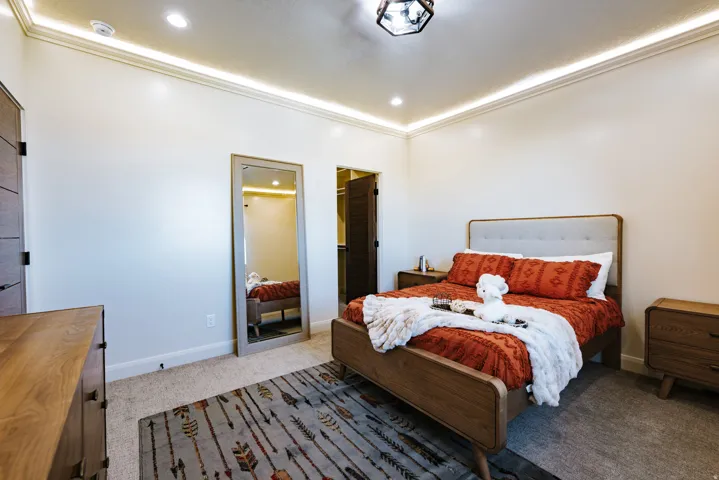 Recessed lighting, crown molding, and wood-finish door with dark hardware