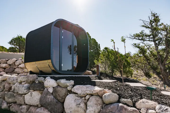 Modern standalone structure with a dark exterior and wood-finish base