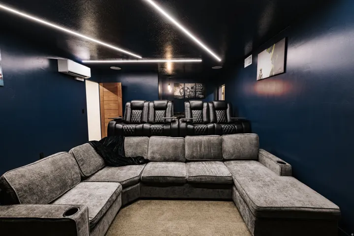 Recessed ceiling lighting, dark-painted walls, and a wood-finish interior door