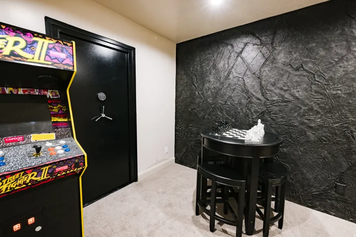 Textured accent wall, neutral carpet flooring, and a recessed ceiling light