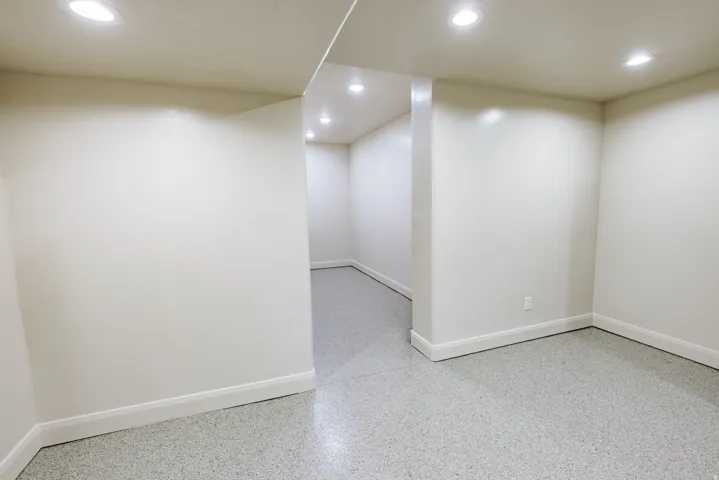Recessed ceiling lighting illuminates the space, featuring light-toned walls and a speckled flooring surface