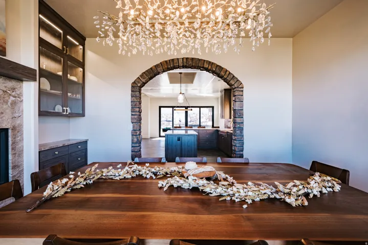 Crystal-leaf chandelier illuminating a stone-clad archway