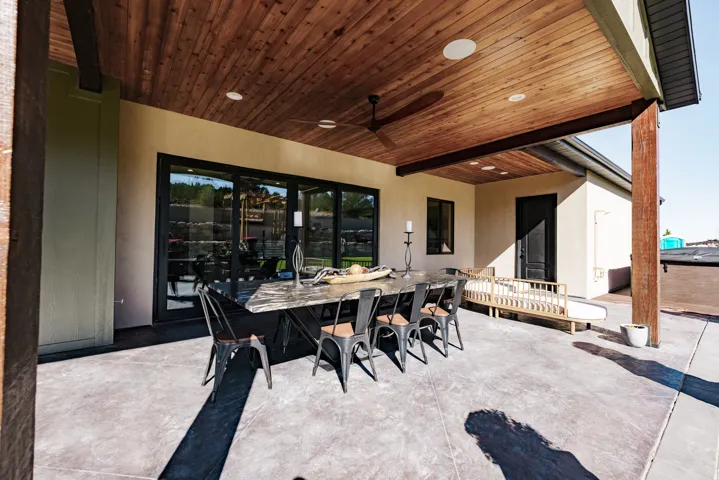 Expansive patio with stamped concrete flooring, wood-paneled ceiling, recessed lighting, and a ceiling fan
