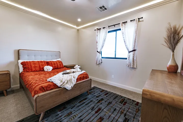 Recessed ceiling lighting, crown molding, a window with dark framing, and carpeted flooring