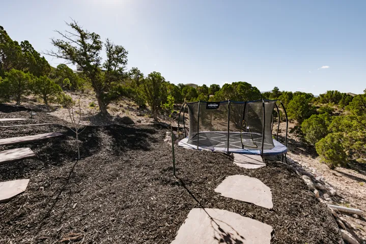 Tiered landscaping featuring natural stone steps, dark-toned ground cover, and mature trees