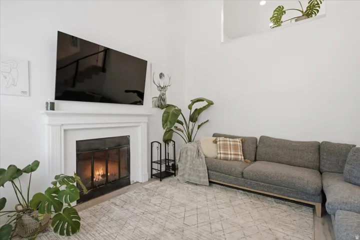 White fireplace mantel, black firebox with glass screen, and recessed lighting