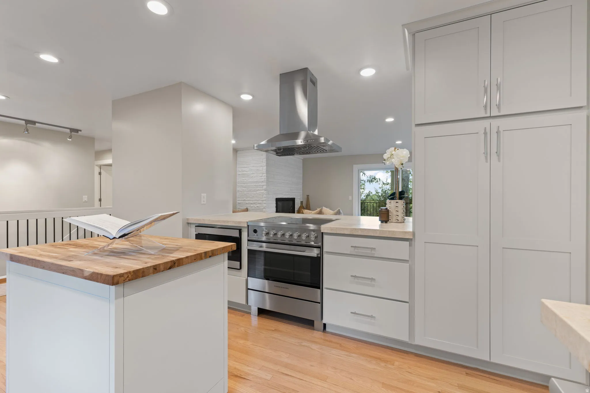 Contemporary kitchen with chef caliber appliances, Taj Mahal quartzite countertops, chrome plumbing fixtures and light, updated cabinetry