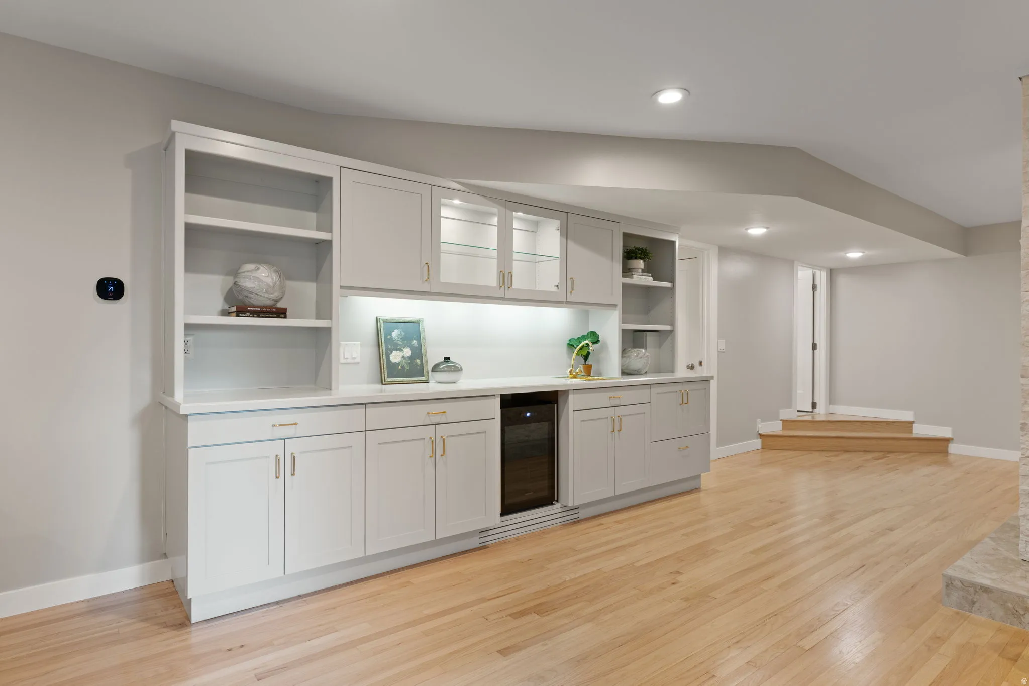 Lower level wet bar with sink, under-counter fridge and integrated lighting