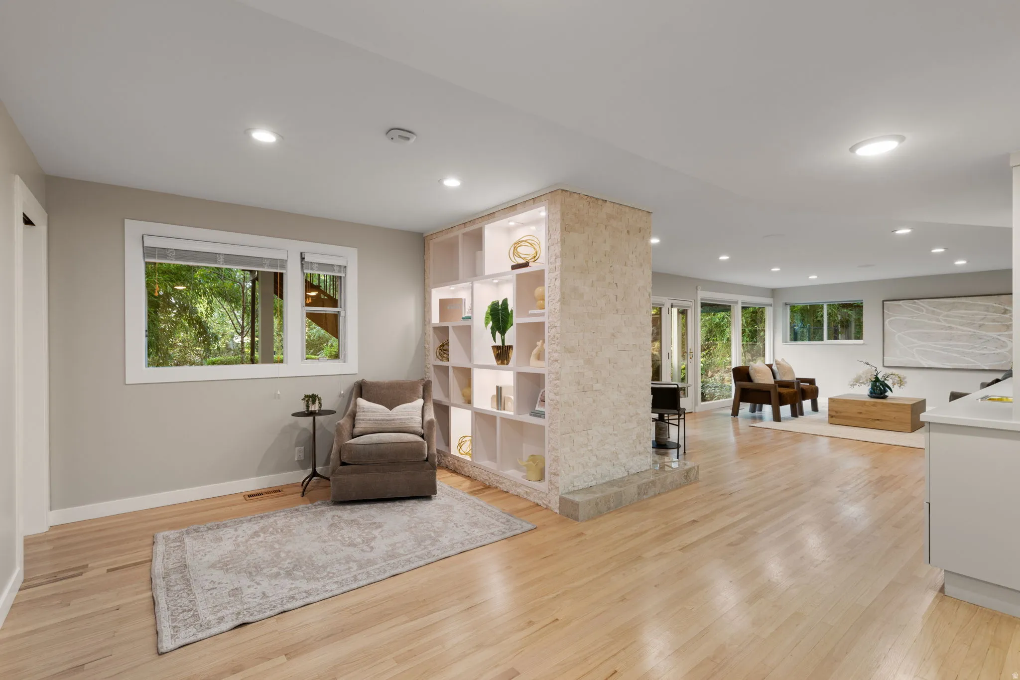 Lower level sitting area with hardwood flooring and built-in shelving and integrated lighting