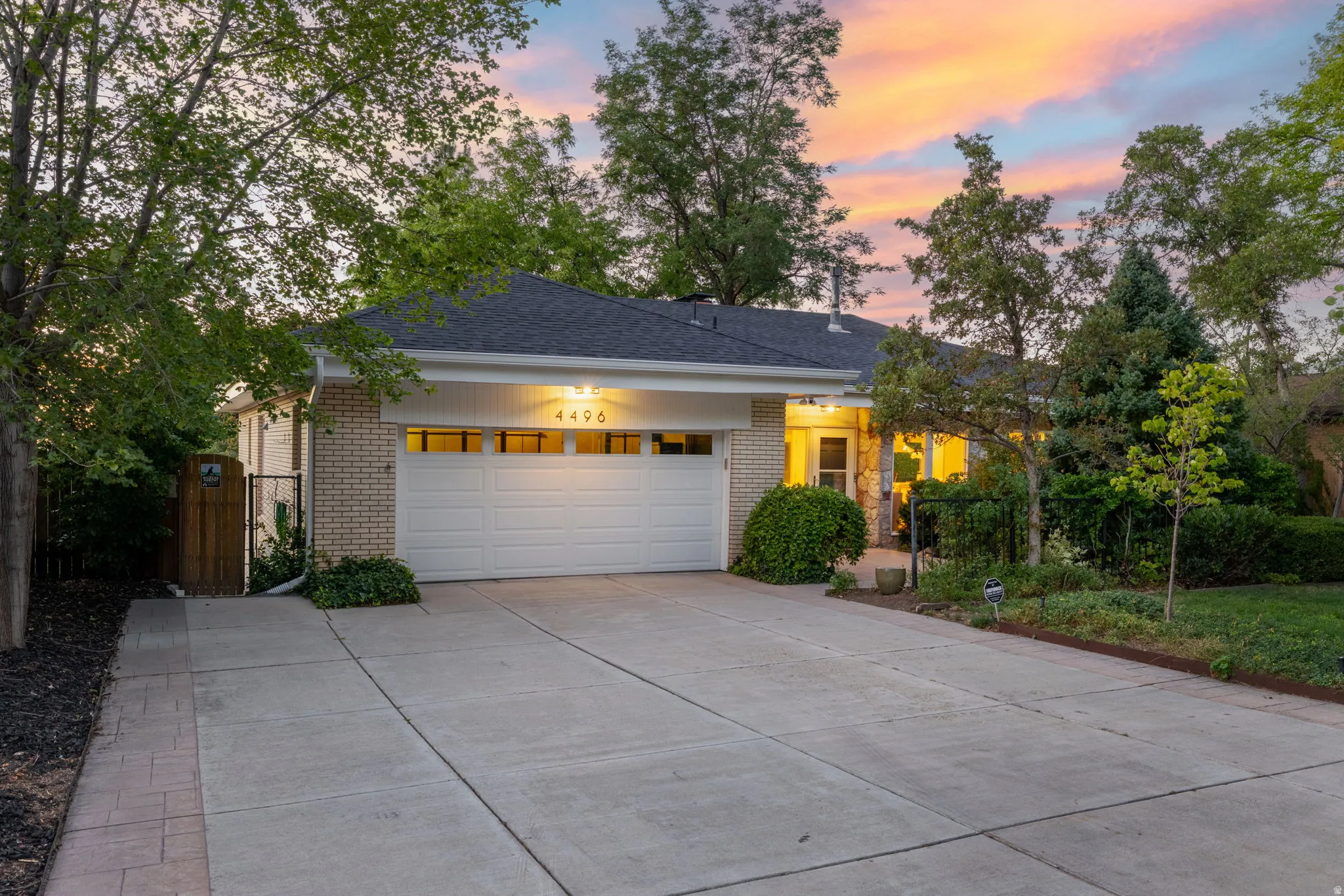 Brick exterior with attached garage and expanded parking area