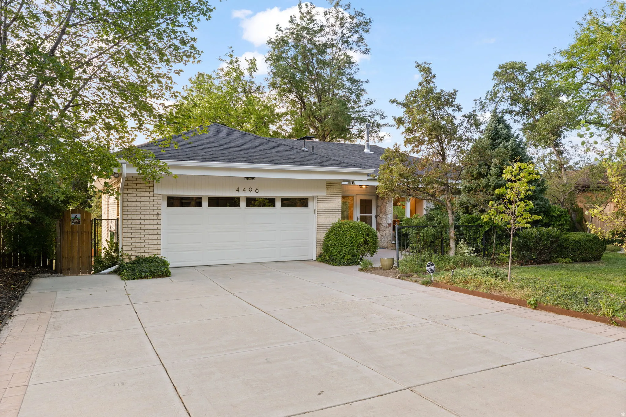 Brick exterior with attached garage and expanded parking area