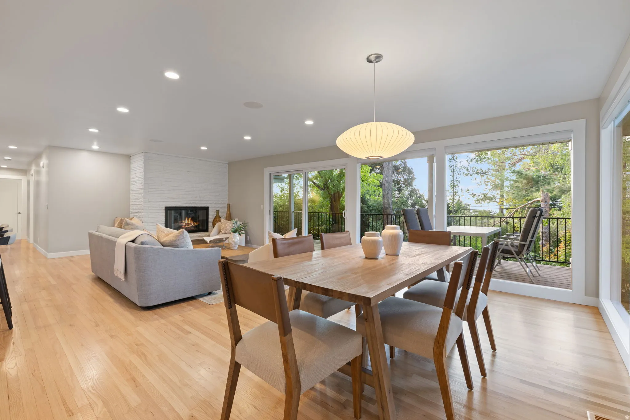 Dining & living space with hardwood flooring, gas fireplace and walkout to backyard deck