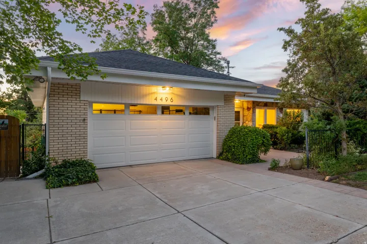 Brick exterior with attached garage and expanded parking area