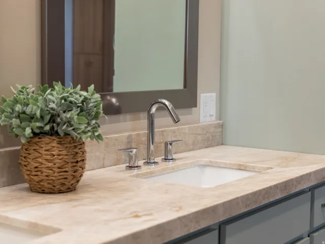 Integrated vanity with an under mount sink, chrome faucet, and Taj Mahal quartzite countertop