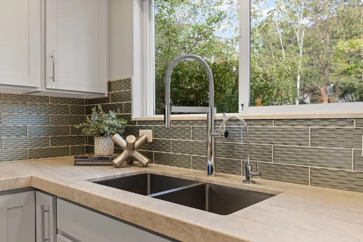 Dual-basin undermount sink with a high-arch chrome faucet and Taj Mahal quartzite countertops