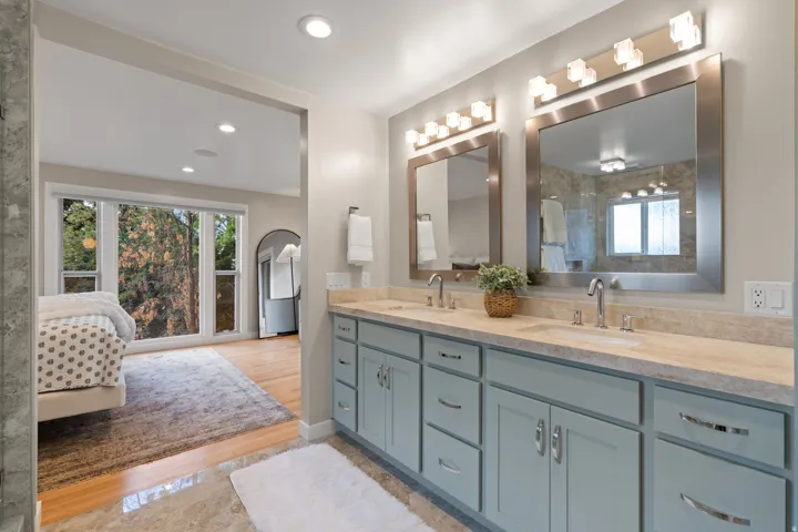 Dual vanity with a Taj Mahal quartzite countertop, under-mount sinks, and framed mirrors