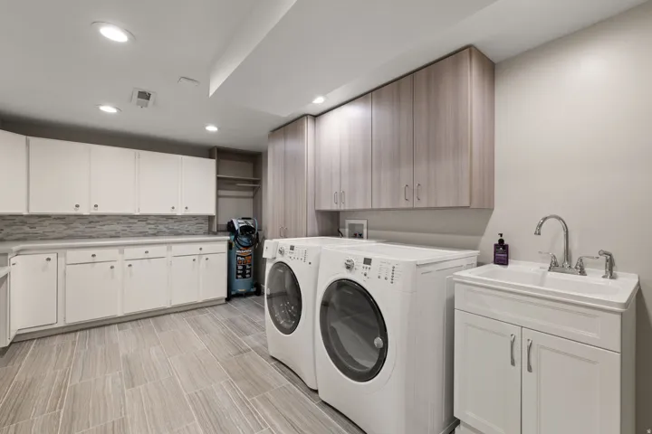Laundry room with work sink and ample storage space