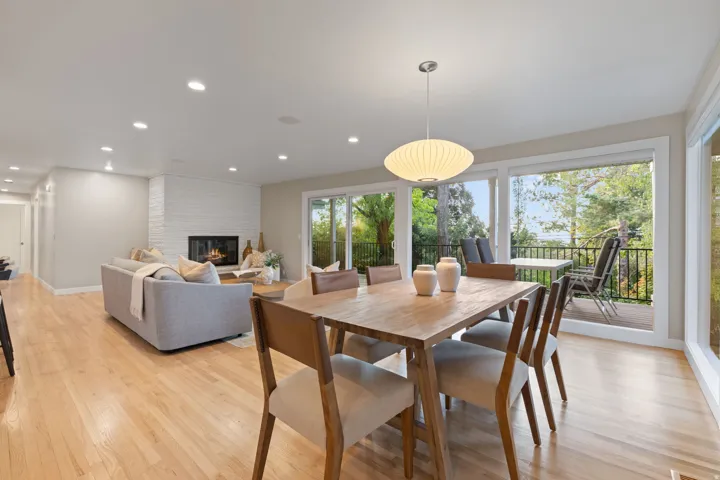 Dining & living space with hardwood flooring, gas fireplace and walkout to backyard deck