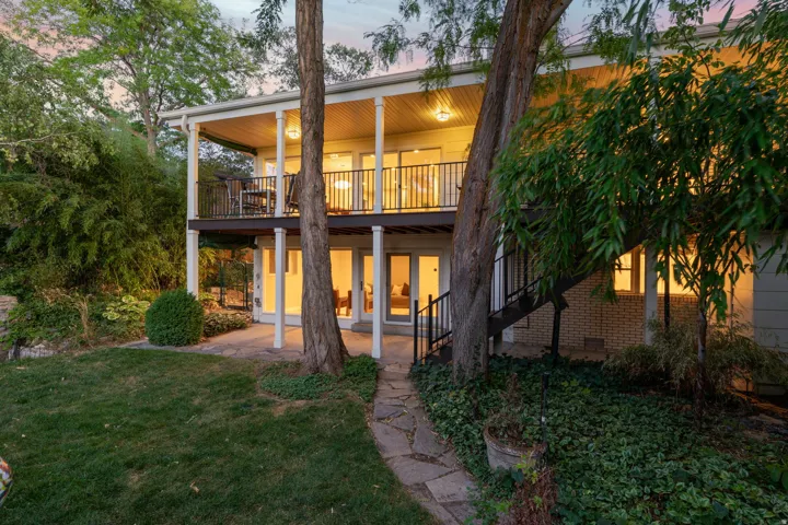 Back of home with walkouts on both levels, updated Trex deck and mature landscaping