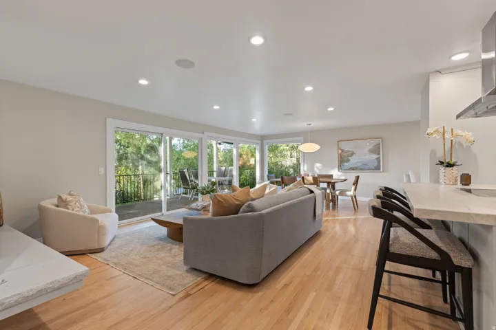 Living room featuring hardwood flooring, contemporary gas fireplace and lush backdrop