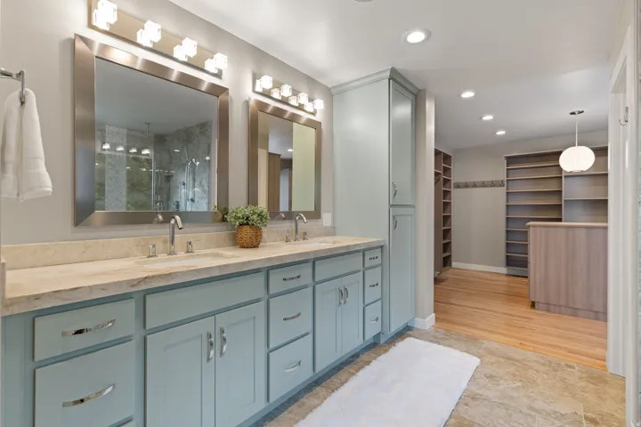 Dual vanity with Taj Mahal quartzite countertops, updated chrome plumbing fixtures and access to expansive primary closet