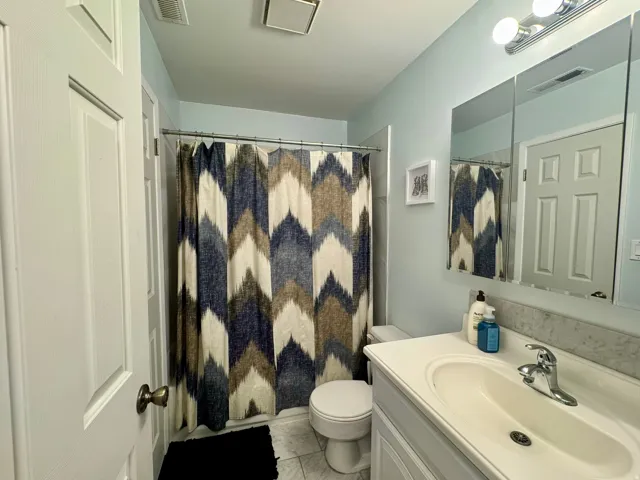 White vanity with integrated sink, chrome faucet, and mirrored medicine cabinet