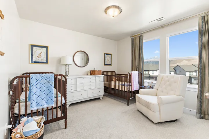 Carpeted flooring with white walls, two large windows, and a flush-mount ceiling light