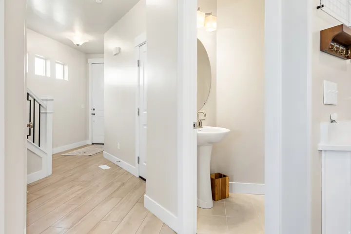 Entryway with wood-finish flooring, a contemporary staircase featuring black iron balusters, and transom windows above the main door