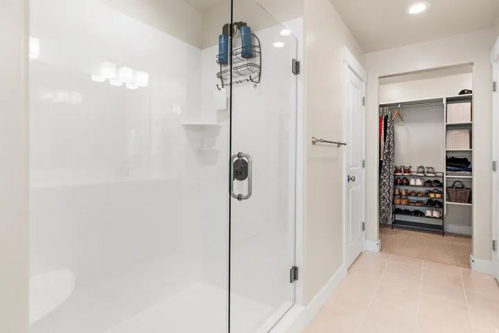 Walk-in shower with clear glass enclosure and built-in bench