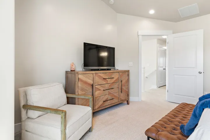 Recessed lighting illuminates the neutral wall tones and carpeted flooring