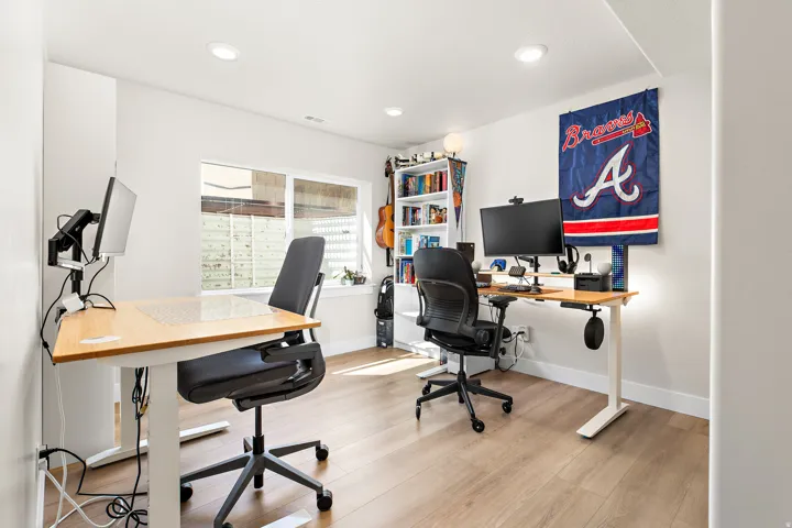 Bright interior space with wood-finish flooring, recessed lighting, and a large window