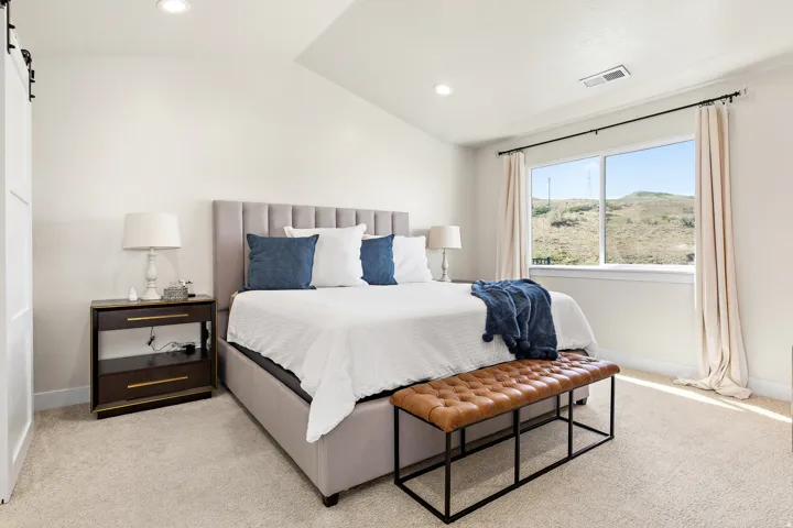 Plush carpet flooring with neutral tone walls, a large window, recessed lighting, and a barn door entry