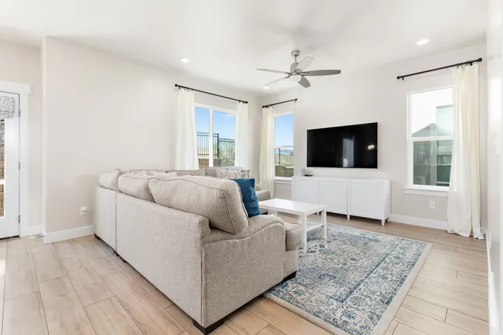 Living area featuring light wood-finish flooring, recessed lighting, and a ceiling fan