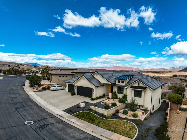 Aerial view - contemporary exterior with a dark tile roof, integrated solar panels, and attached two-car garage