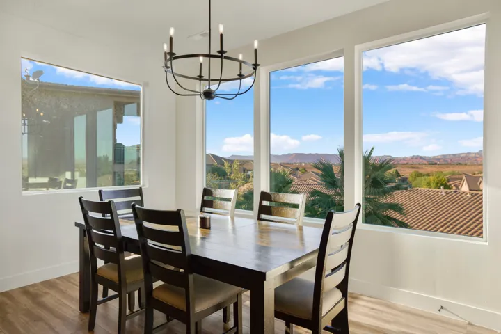 Wood-finish flooring, ample natural light, and a modern black chandelier