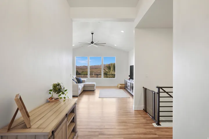 Open concept living area with vaulted ceiling, lvp wood-finish flooring, recessed lighting, and a modern ceiling fan