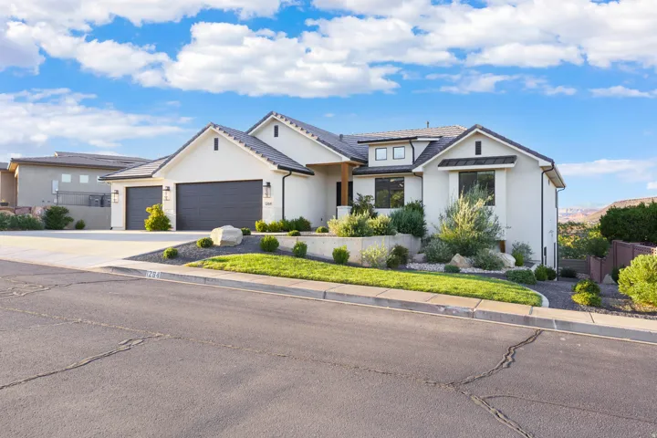 Contemporary stucco exterior with a multi-car garage, mature landscaping, and a well-defined driveway