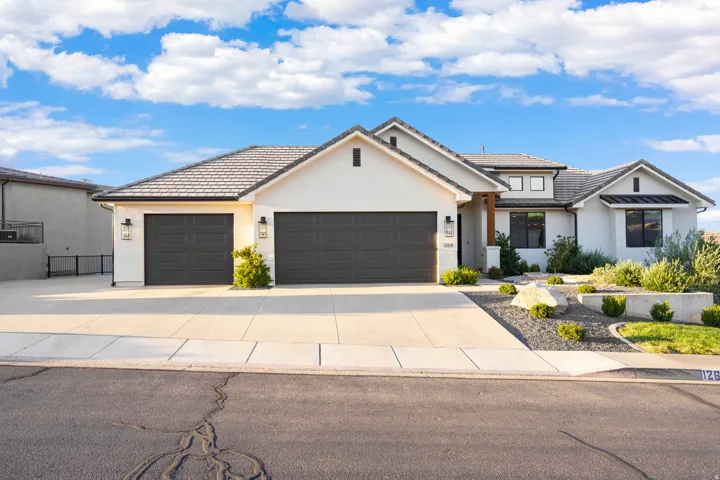 Contemporary exterior with a multi-gabled roofline and light-colored stucco