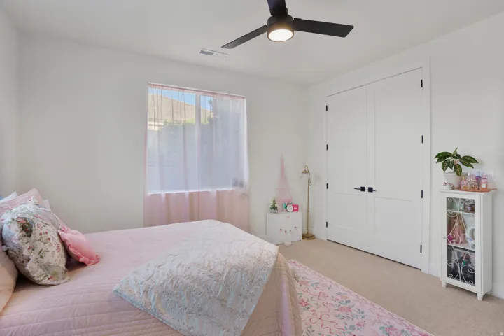 Recessed window, white paneled doors, black ceiling fan with integrated lighting, neutral-toned carpet