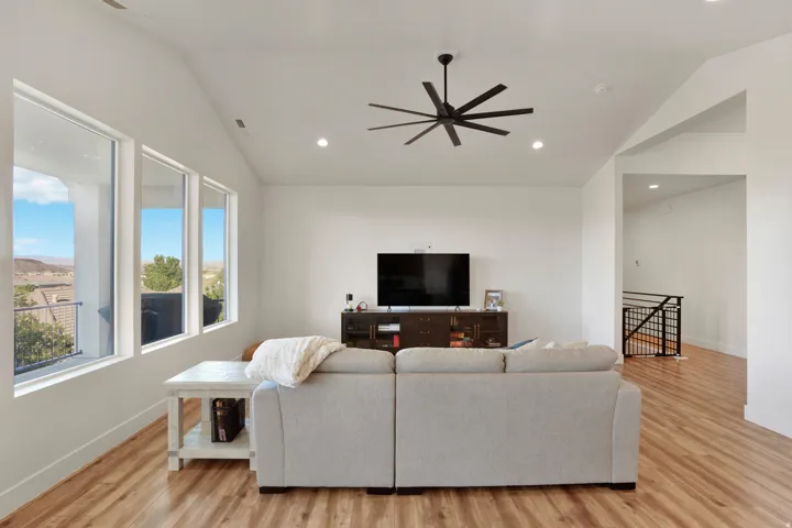 Vaulted ceilings with recessed lighting, wood-finish flooring, and a contemporary ceiling fan