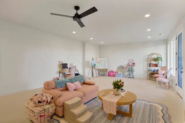 Expansive room featuring recessed lighting, a ceiling fan, light-colored carpeting, and double glass-paneled doors